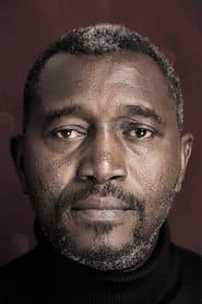 Issaka Sawadogo في دور Driss (Taxi driver)