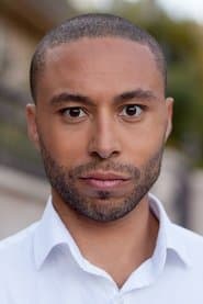 Alexis Rodney dans le rôle de First Hotel Receptionist